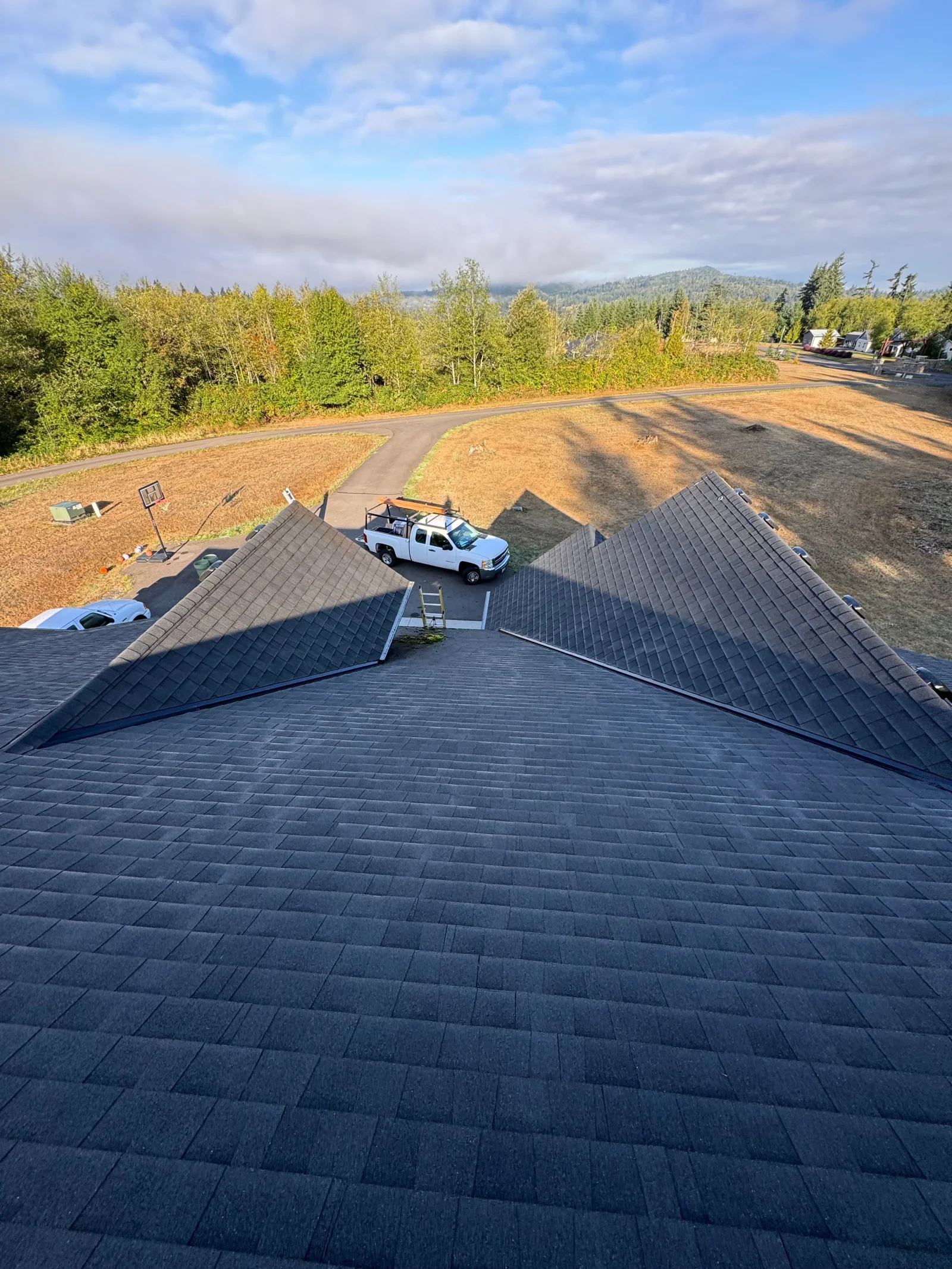 Dark gray architectural asphalt shingles installed on multi-pitched roof with complex angles and valleys