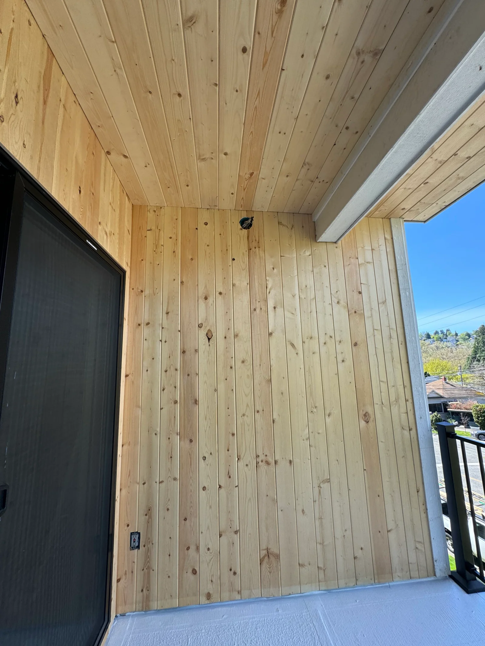 Knotty pine vertical shiplap walls and ceiling with aluminum trim in covered porch