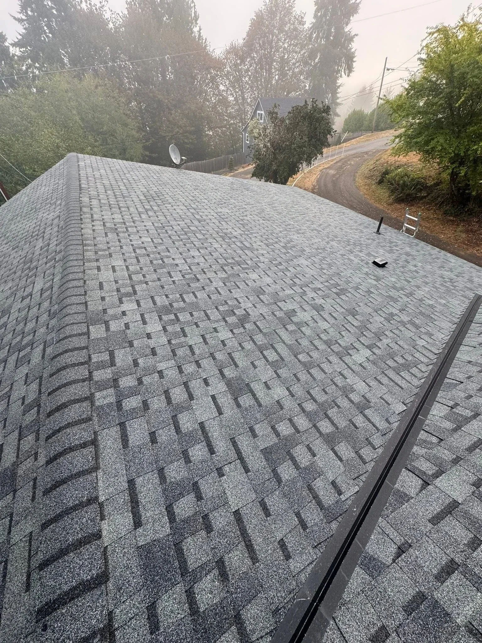 Gray architectural shingles installed in dimensional pattern on residential roof with proper overlap and drip edge