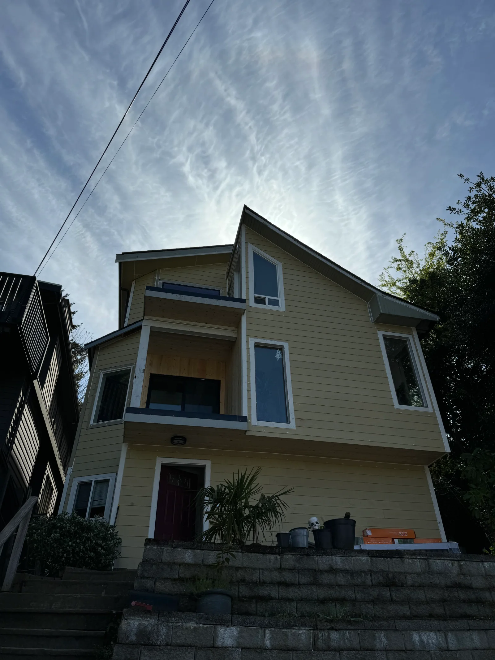 Three-story home with new tan fiber cement siding and white-trimmed replacement windows