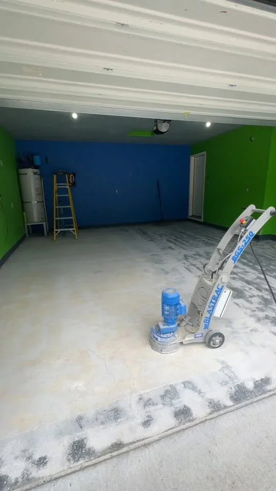 Concrete floor grinding machine on polished floor with green and blue painted walls and white ceiling