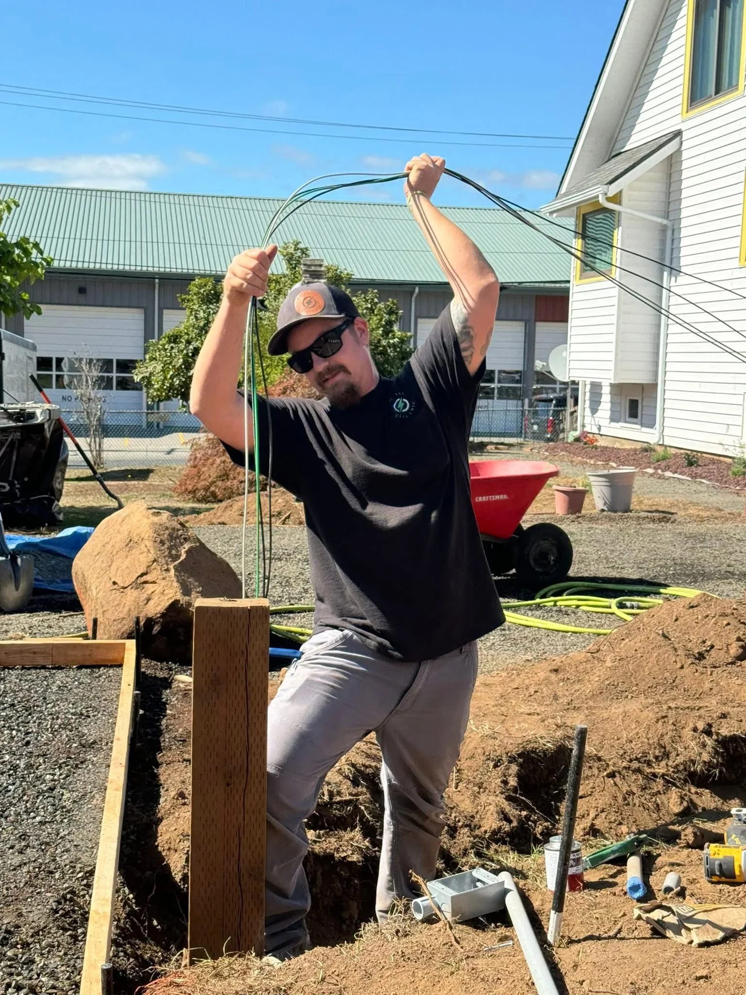 Technician installing underground irrigation lines with PVC pipe and trenching in residential yard